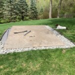 The landscape fabric is in place and rock is being added. Note the supervisor. Adding Rock